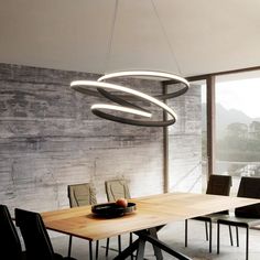 a dining room table with chairs and a light fixture hanging from it's ceiling