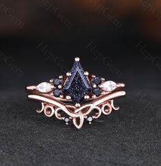 a ring with blue and white stones in it on top of a black tablecloth