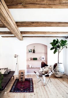 the instagram page for mydomaine shows an image of a living room with white walls and wood beams