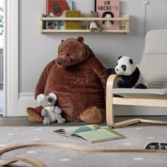 two stuffed animals sitting on the floor next to a chair