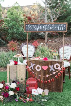 an outdoor dessert table decorated with flowers and decorations for a valentine's day party