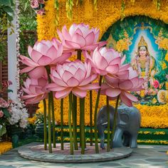 large pink flowers in front of a shrine with an elephant statue