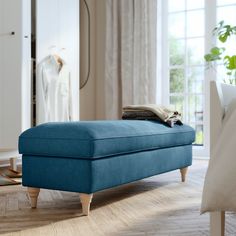 a grey ottoman sitting on top of a hard wood floor