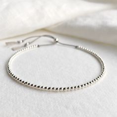 A beautiful dainty grey silk beaded bracelet with sterling silver beads and sliding clasp to adjust to your size. Looks great alone as a minimalist bracelet or can be stacked with other bracelets. Comes displayed in one of our pretty gift boxes, so fantastic as a present for a friend or to yourself! Shipping Uk: 2-3 days - Royal Mail 48hr tracked International standard delivery: 6- 14 days (delays can occur especially in busy periods) Please be aware that standard shipping is UNTRACKED and does not need to be signed for but you do have the option to upgrade to tracked and signed shipping (someone must be available to sign for the parcel on delivery) International orders over £50 will automatically be upgraded to tracked and signed shipping at no extra charge DETAILS - Grey silk cord - Ster Elegant Silver Bracelet With Sliding Knot, Silver Sterling Silver Friendship Bracelets For Everyday, Adjustable Hand-strung Silver Friendship Bracelets, Silver Jewelry With Sliding Knot And Round Beads, Minimalist Sterling Silver Bracelet With Silver Beads As Gift, Silver Jewelry With Round Beads And Sliding Knot, Minimalist Silver Beaded Bracelets, Minimalist Sterling Silver Bracelet With Round Beads, Minimalist Silver Bracelets With Tiny Beads