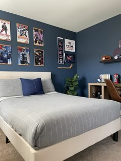 a bedroom with blue walls and pictures on the wall