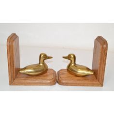 two golden ducks sitting on top of wooden bases