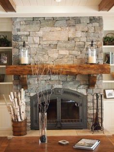 a living room with a stone fireplace and bookshelves