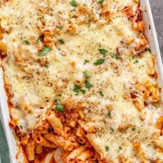 a casserole dish filled with pasta and meat, topped with parmesan cheese