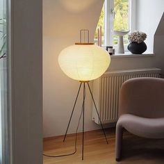 a floor lamp sitting in front of a window