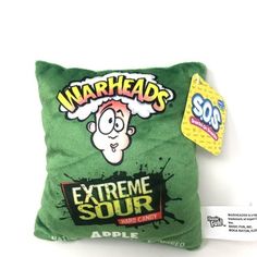 a green pillow sitting on top of a white table next to a package of gum