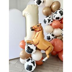 an inflatable horse and ballons on the floor next to a balloon wall