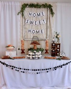 a table topped with cakes and desserts under a sign that says home sweet home