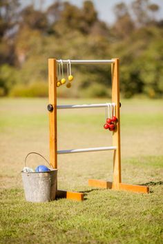 an outdoor game set up in the grass with buckets and balls next to it