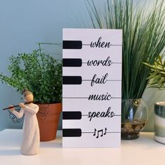 a small figurine is next to a sign that says when words fail music speaks