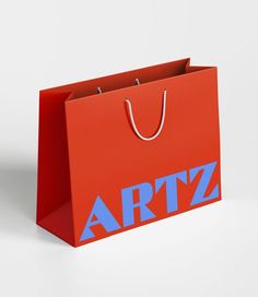 a red shopping bag with the word artz on it's front and side