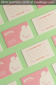 several business cards with pink and green designs on them, all lined up in rows