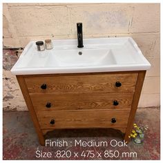 a bathroom sink sitting on top of a wooden cabinet next to a brick wall with the words finish medium oak size