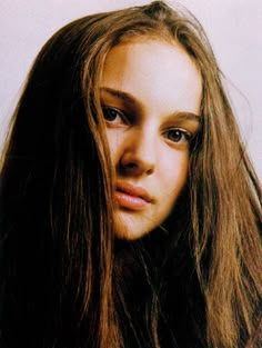 a young woman with long brown hair looking at the camera