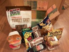 an assortment of food items sitting on top of a wooden floor next to a bag