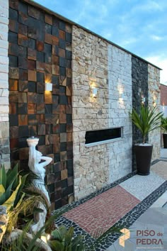 a stone building with a fountain and potted plants