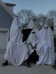 three people dressed up in ghost costumes