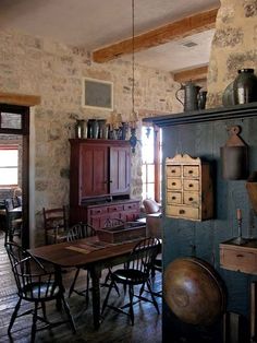 an old fashioned kitchen and dining room with stone walls