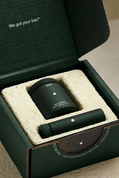 an open green box with a black object inside