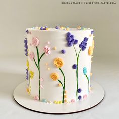 a white cake decorated with flowers and leaves