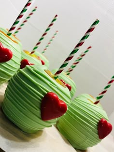 cupcakes with green frosting and candy canes in the shape of hearts