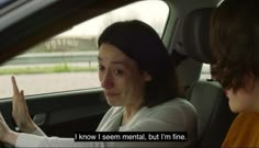 a woman sitting in the driver's seat of a car talking to another woman