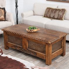 a wooden coffee table sitting on top of a hard wood floor next to a white couch