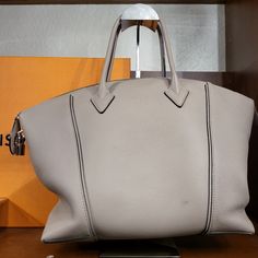 This Is An Authentic Louis Vuitton Veau Cachemire Soft Lockit Mm In Galet. This Stylish Tote Is Crafted Of Grained Cachemire Calfskin Leather In Grey-Beige. The Bag Features Rolled Leather Top Handles And A Removable, Adjustable Shoulder Strap With Silver Hardware. The Top Zipper Opens To A Suede Interior With Zipper And Patch Pockets. Luxury Gray Shoulder Bag With Top Carry Handle, Luxury Gray Bag With Top Carry Handle, Luxury Gray Satchel Bag, Luxury Gray Bag With Palladium Hardware, Designer Gray Bags, Luxury Gray Bag With Removable Pouch, Luxury Gray Top Handle Satchel, Designer Gray Bag With Detachable Handle, Designer Gray Bags With Detachable Handle