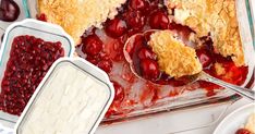 cherry cobbler in a glass dish with spoons and cherries