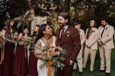 a bride and groom standing in front of their wedding party