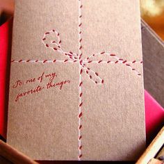 a brown card with red thread on it