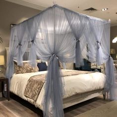 a canopy bed with sheer curtains over it