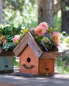 two wooden bird houses with flowers in them