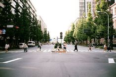 people crossing the street at an intersection on a sunny day