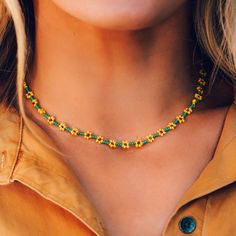 a woman wearing a necklace with yellow and green beaded beads on her neckline