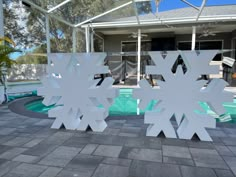 two large snowflakes sitting in front of a swimming pool