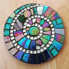 a multicolored circular mosaic on top of a wooden table