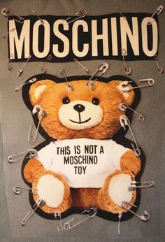 there is a teddy bear that has been pinned to the back of a shirt with words moschino on it