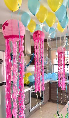 balloons and streamers are hanging from the ceiling in this party - like kitchen area