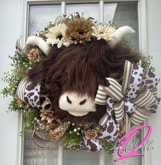 a stuffed animal hanging from the side of a door with flowers on it's head