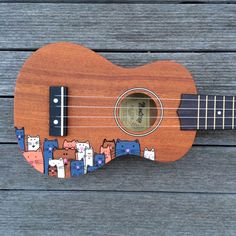 an ukulele is sitting on a wooden surface