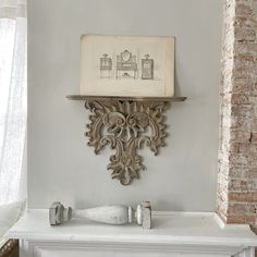 an old fireplace with a drawing on the mantle