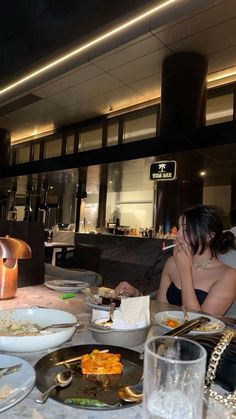 two women sitting at a table with plates of food