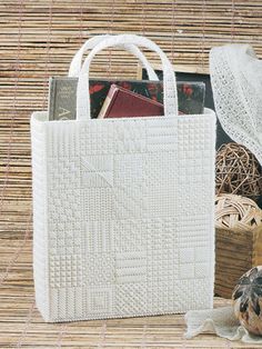 a white bag sitting on top of a table next to some books and other items