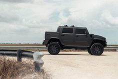 a black hummer truck is parked on the side of the road