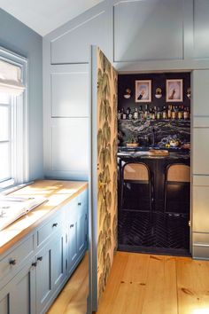 an open door leading into a kitchen with wooden floors